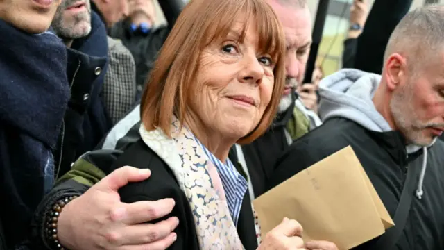 Gisèle Pelicot smiles as she leaves the courthouse holding a brown envelope