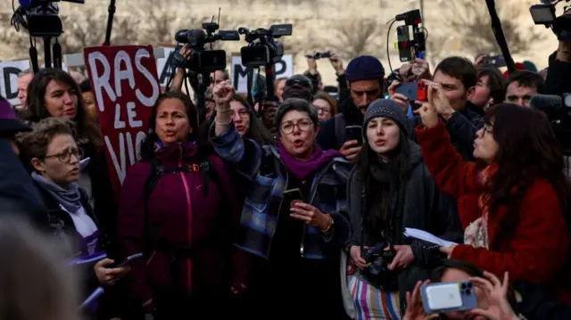 Supporters cheer as they await the exit of Gisèle Pelicot outside the courthouse after the hearing of the verdict