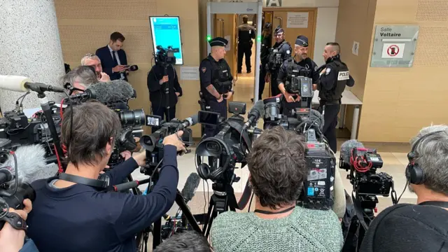 Journalists pointing cameras at a court room