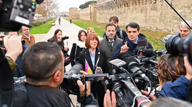 Gisele Pelicot is surrounded by journalists as she arrives with her lawyers Stephane Babonneau and Antoine Camusto to attend the verdict in the trial