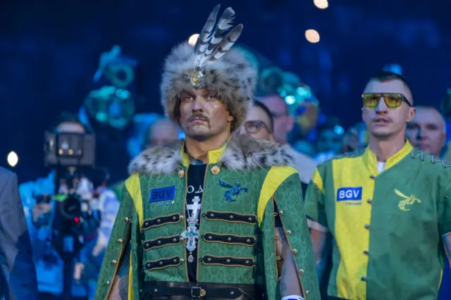 Oleksandr Usyk wearing a green outfit with a fur hat