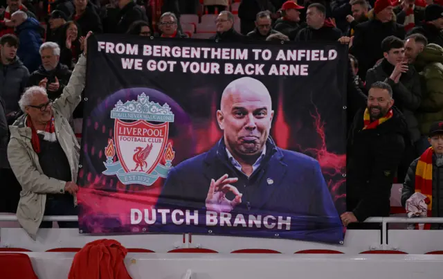 Two Liverpool fans from the club's "Dutch branch" hold up a banner of Arne Slot