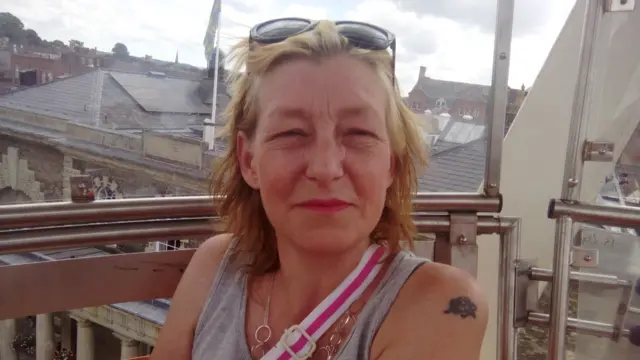 Photo of Dawn Sturgess, who has sunglasses on her head and is wearing a grey vest top