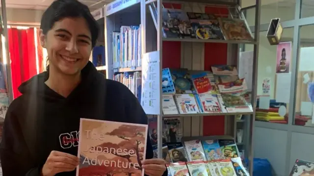 Rozanna Mohammed holding a book titled The Japanese Adventure