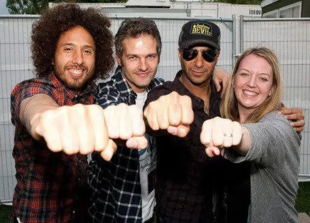 Four people with fists pointing toward the camera