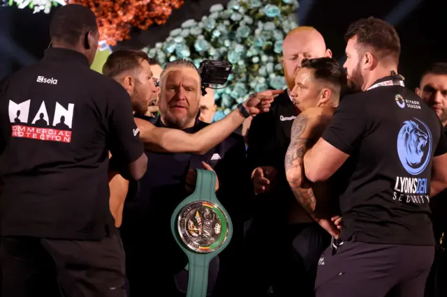 Isaac Lowe shouts as he is dragged away from Lee McGregor at a weigh-in