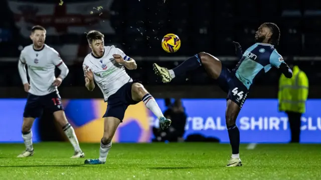 Bolton's George Thomason challenges for the ball with Wycombe's Fred Onyadinma