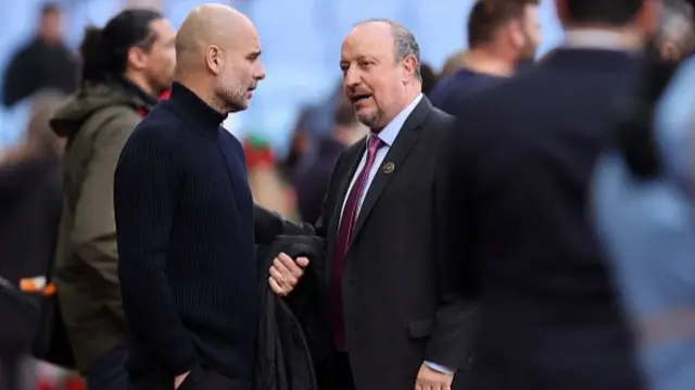 Pep Guardiola Manager of Manchester City speaks with Rafa Benitez