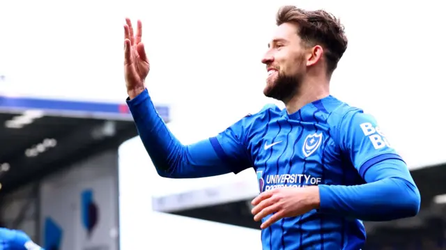 Portsmouth's Callum Lang holds up four fingers to celebrate his fourth goal