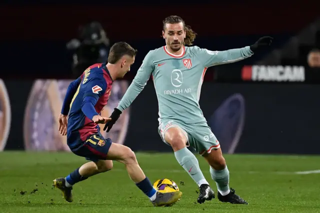 Antoine Griezmann (R) is challenged by Barcelona's Spanish midfielder #17 Marc Casado