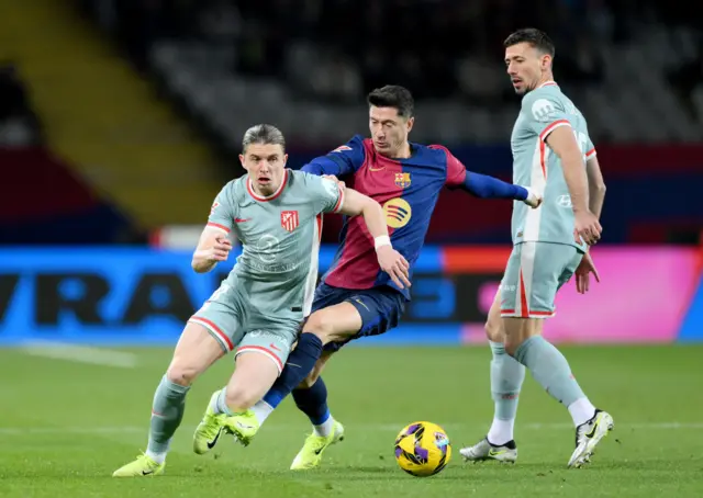 Conor Gallagher of Atletico de Madrid is challenged by Robert Lewandowski of FC Barcelona