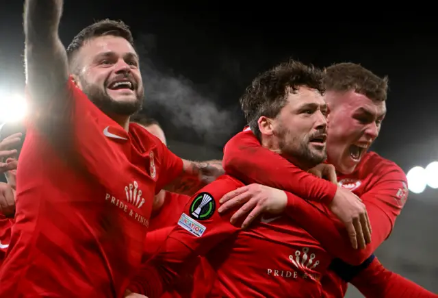 Tomas Cosgrove is embraced by team-mates after scoring Larne's winner against Gent