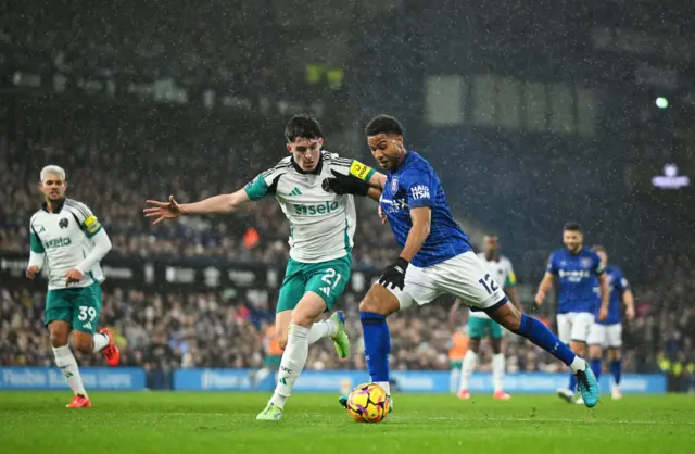 ens Cajuste of Ipswich Town shoots whilst under pressure from Tino Livramento of Newcastle United during the Premier League match between Ipswich Town FC and Newcastle United FC at Portman Road on December 21, 2024 in Ipswich, England.