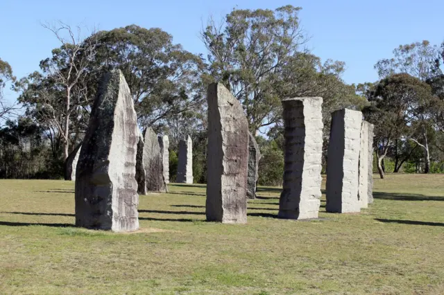 A circle of tall, long stones in a field