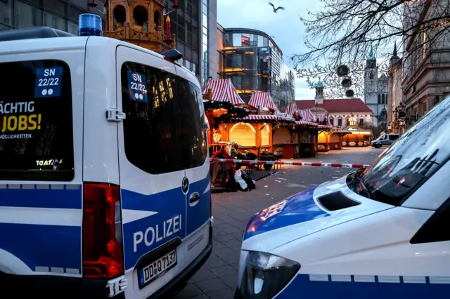 German police vehicles are stationed beside a cordoned off area at the scene of a vehicle-ramming attack on the Christmas market in Magdeburg, Germany