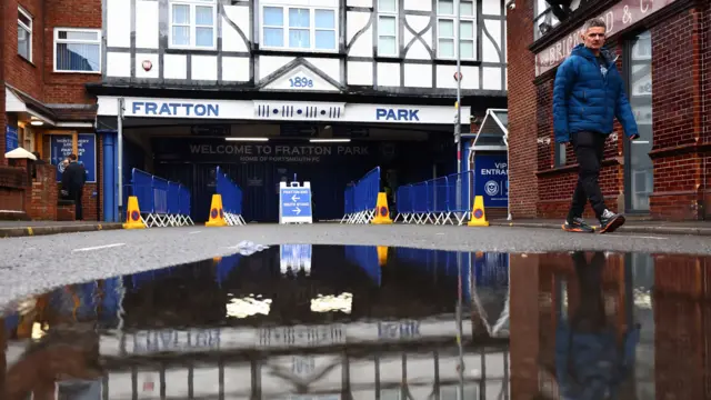 A puddle shows the reflection of Fratton Park