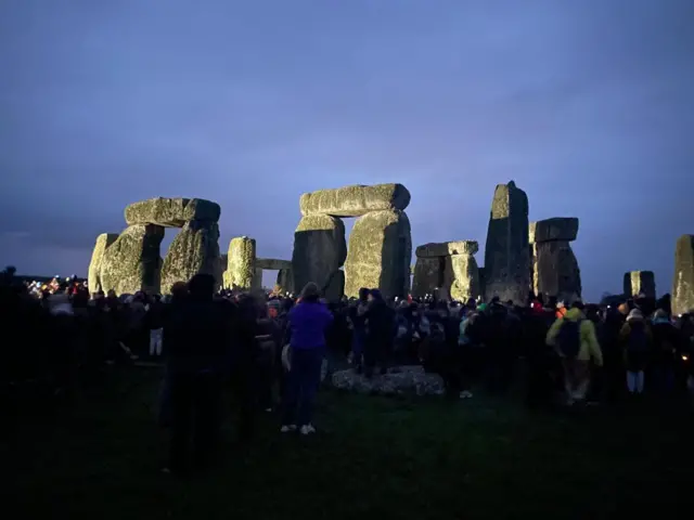 A crowd of people around Stonehenge