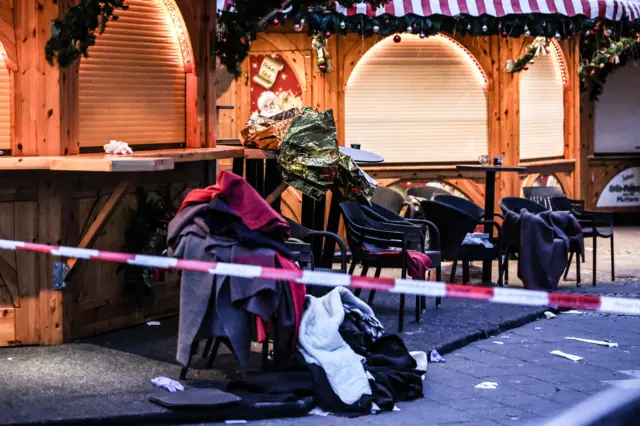 Piled up clothes left behind at a cordoned off area at the scene of a vehicle-ramming attack on the Christmas market in Magdeburg, Germany