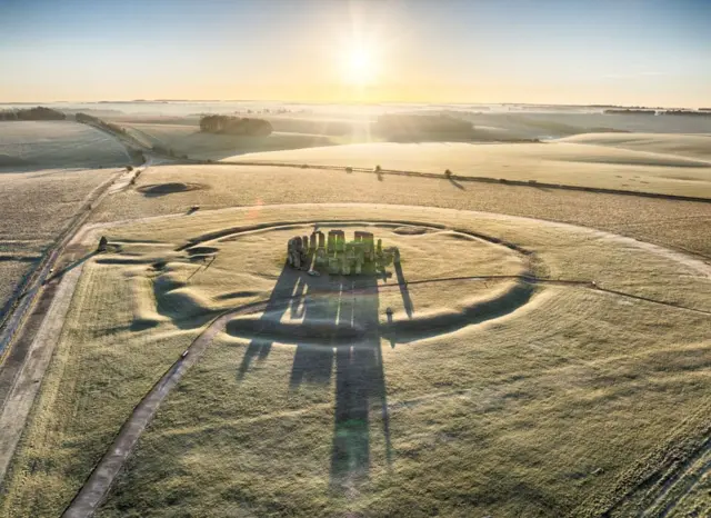 Stonehenge seen from above, with a clear ditch and small mounds forming a circle around the stones