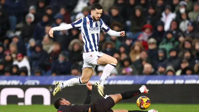 Mikey Johnston is challenged with the ball