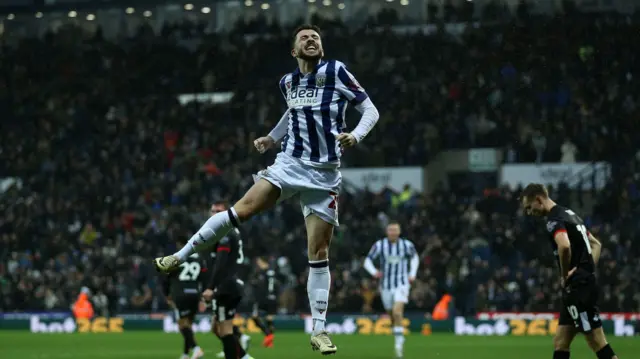 Mikey Johnston jumps in the air to celebrate a goal