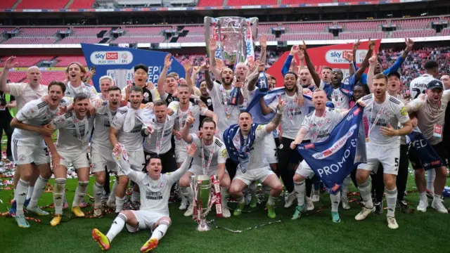 Crawley Town players celebrate winning promotion from League Two