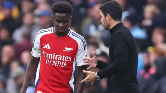 Mikel Arteta speaking to Bukayo Saka