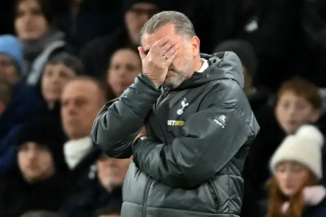 Ange Postecoglou covering his face with his hand during Tottenham's defeat to Liverpool