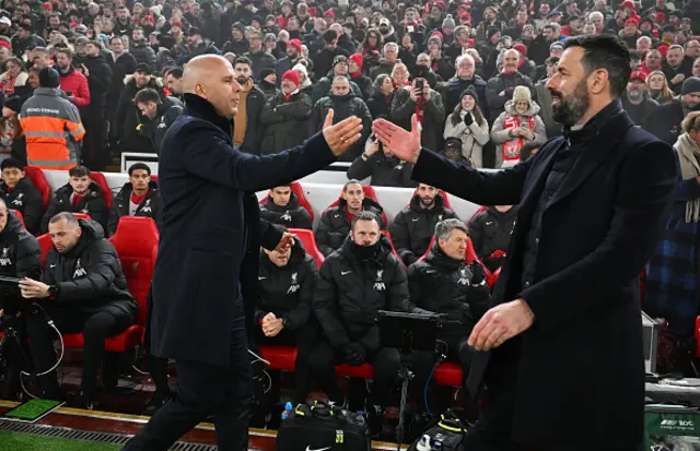 Arne Slot, Manager of Liverpool, shakes hands with Ruud van Nistelrooy,