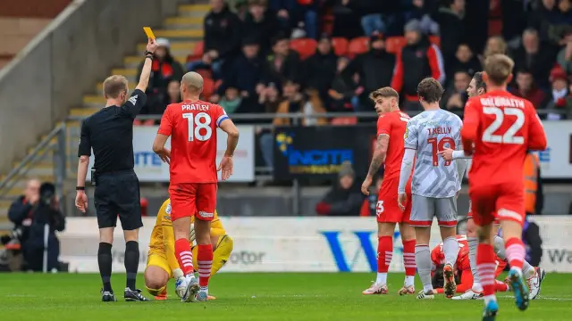 Crawley goalkeeper JoJo Wollacott is yellow carded