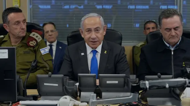 Benjamin Netanyahu sitting at a desk, looking into the camera.