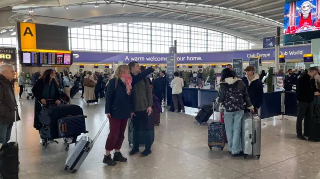 Passengers queue near the check in desks at Heathrow's Terminal 5.