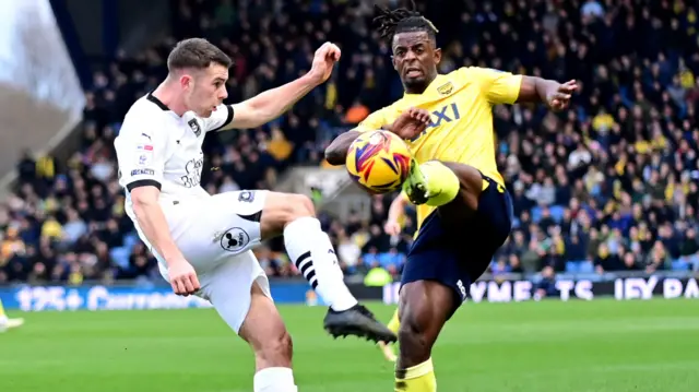 Oxford United defender Greg Leigh (22) battles for possession with Plymouth Argyle midfielder Adam Randell