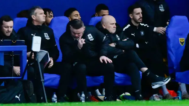 Wayne Rooney sat in the Plymouth dugout