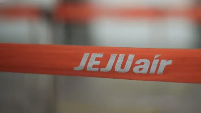 An orange line divider with the Jeju air logo on it can be seen against a blurry background.