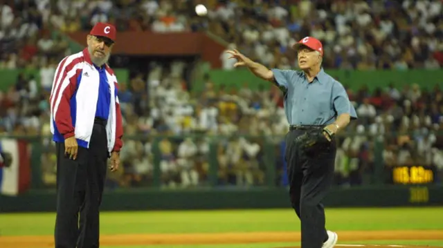 Castro watches as Carter throws a baseball in a packed stadium