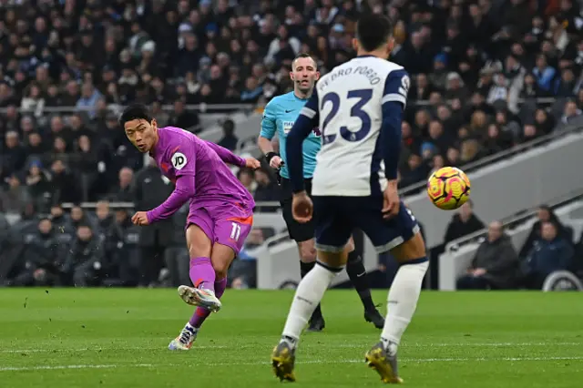 Hwang Hee-chan (L) shoots to score the opening goal