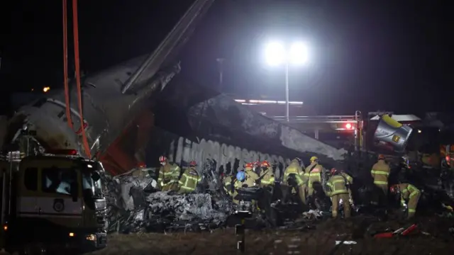 Firefighters work near the wreckage of a Jeju Air aircraft at Muan International Airport in Muan, South Jeolla Province, South Korea