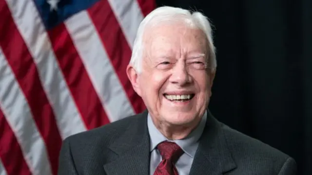 Jimmy Carter with an American flag behind him