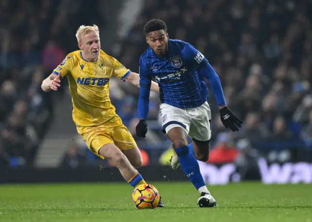 Jens Cajuste of Ipswich Town runs with the ball under pressure from Will Hughes of Crystal Palace