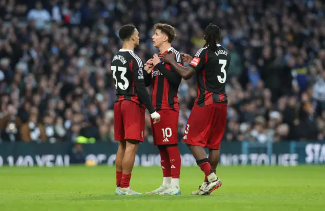 Tom Cairney being comforted by two players.