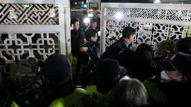 Police officers close the gate of the National Assembl