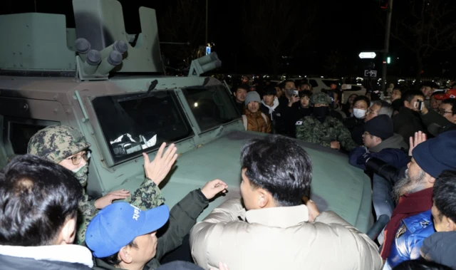 People surrounded a military vehicle outside the National Assembly in Seoul after South Korean President Yoon Suk Yeol declared martial law