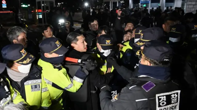 Police attempt to hold back people trying to enter the National Assembly in front of the main gate of the National Assembly in Seoul