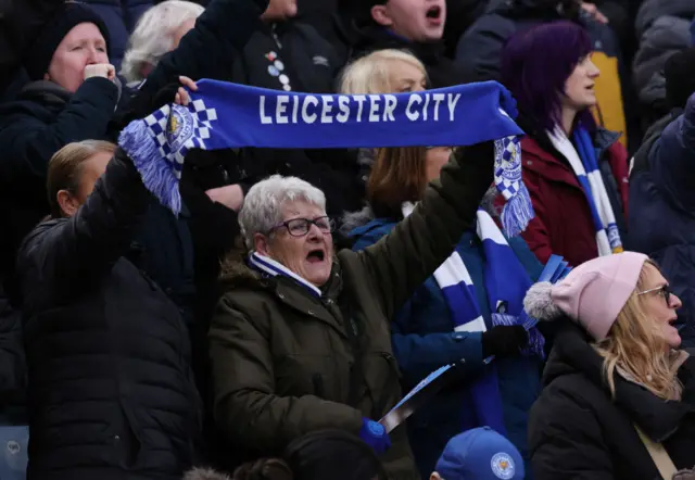 Leicester fans hold up a scarf while singing