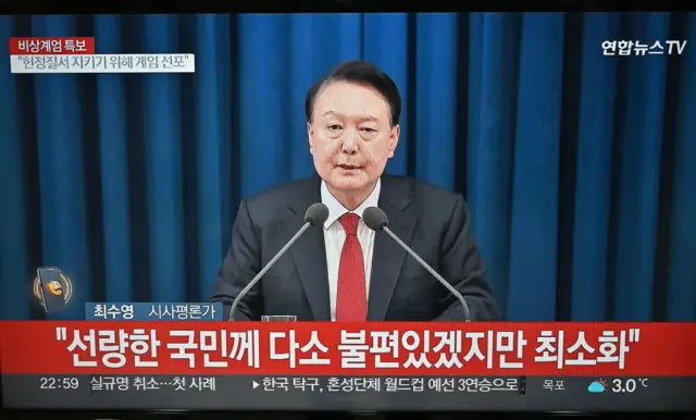 A television screen shows a news broadcasting of South Korean President Yoon Suk Yeol delivering a speech on emergency martial law, in Goyang, northwest of Seoul, on December 3, 2024