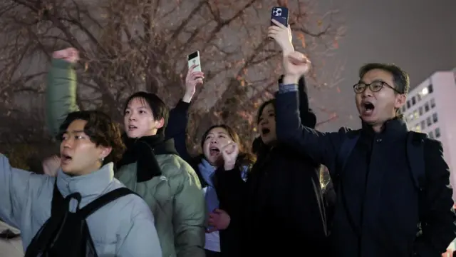 People shout slogans in front of the gate of the National Assembly, after South Korean President Yoon Suk Yeol declared martial law