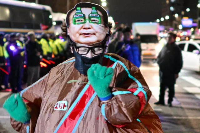 A protester dressed as Yoon