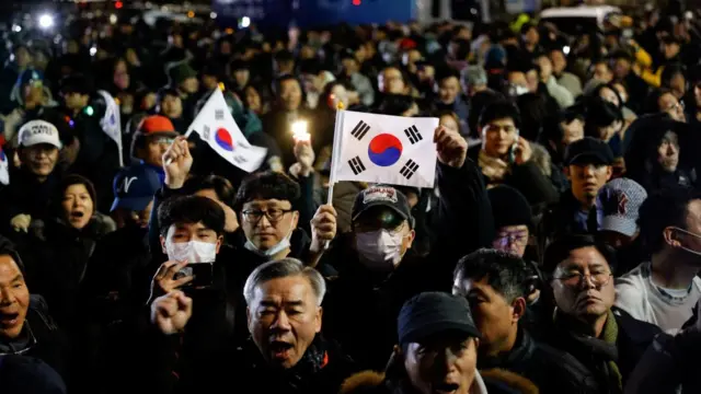 People gather outside the National Assembly in Seoul, South Korea after South Korean President Yoon Suk Yeol declared martial law