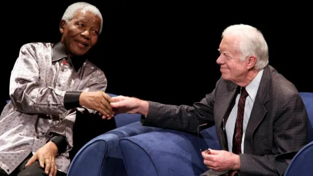 Nelson Mandela and Jimmy Carter shake hands in 2007.